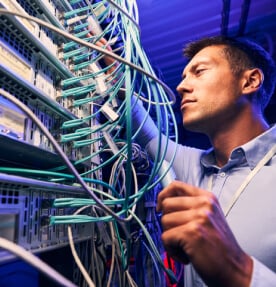 Un técnico revisa el cableado de un rack de servidores. 