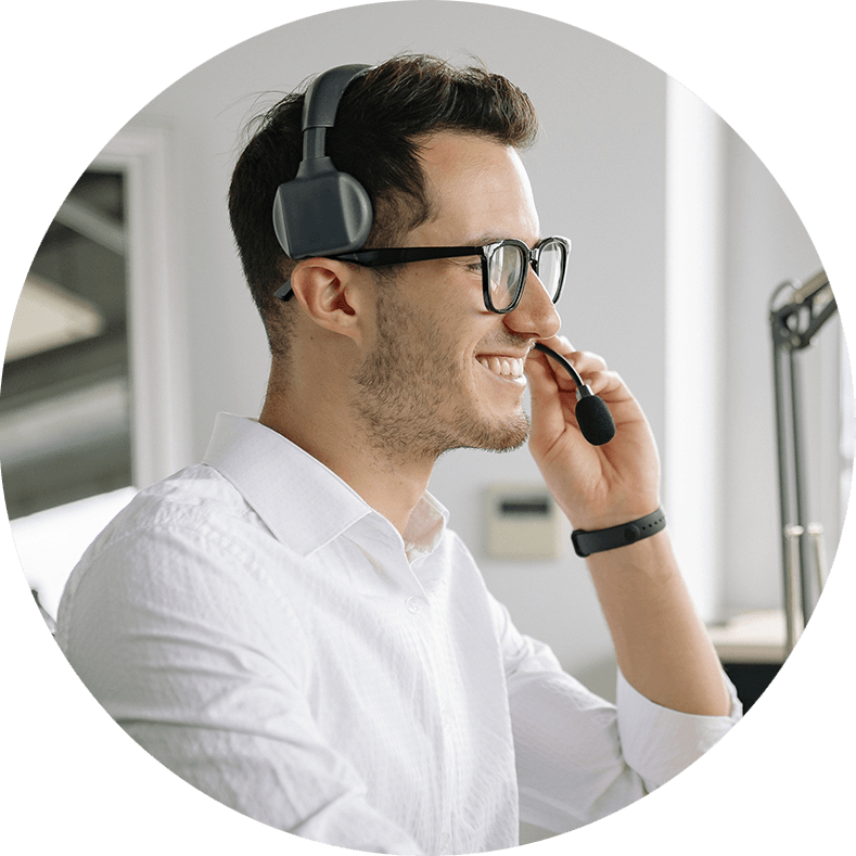 Foto de un asesor de ventas recibiendo la llamada de un cliente. Trae una diadema en la cabeza para poder comunicarse. 